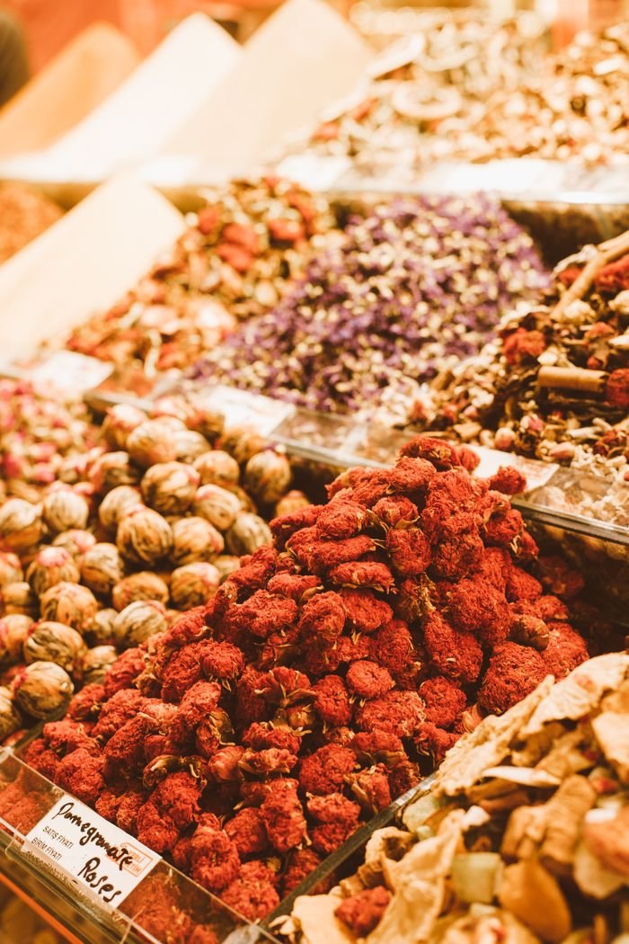 Colorful assortment of dried fruits and spices in a bustling market stall.